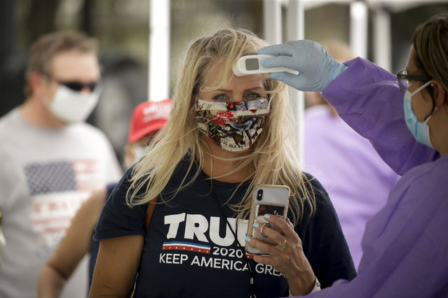 A supporter gets her temperature checked prior to attending a campaign rally for President Trump at the BOK Center in Tulsa, Okla., Saturday, June 20, 2020. (Photo by Charlie Riedel/AP Photo)