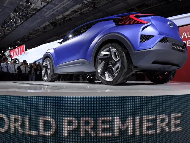 Members of the press take pictures of a Toyota C-HR Concept car displayed at the 2014 Paris Auto Show on October 2, 2014 in Paris, on the first of two press days. (Photo by Eric Piermont/AFP Photo)