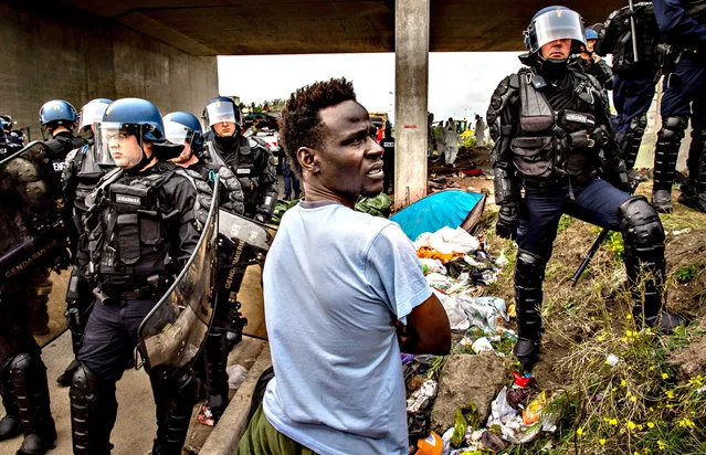French gendarmes proceed with operations during the eviction of around 200 refugees from a camp site in Calais, northern France, on September 21, 2015. Thousands of migrants over the summer attempted to cross the Channel Tunnel between Britain and France, which later stepped up border controls. (Photo by Philippe Huguen/AFP Photo)