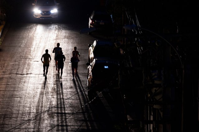 Joggers exercise on a dark street in San Juan, Puerto Rico on December 31, 2024, after a major power outage hit the island. (Photo by USA Today)