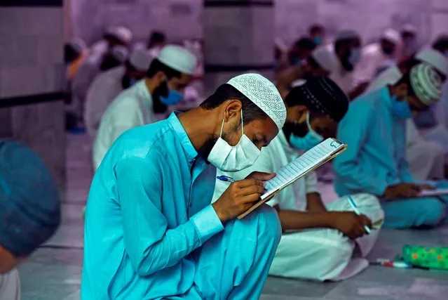 Islamic religious students wearing facemasks as a preventive measure against the spread of the COVID-19 coronavirus, attend their final examination at the Jamia Muhammadia seminary in Islamabad on July 13, 2020. (Photo by Aamir Qureshi/AFP Photo)