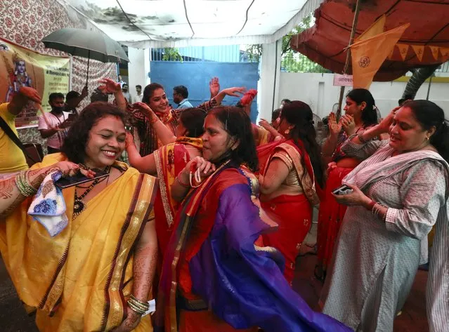 Hindu women dance to celebrate ahead of a groundbreaking ceremony of a temple dedicated to the Hindu god Ram in Ayodhya, at the Vishwa Hindu Parishad, or World Hindu Council, headquarters in New Delhi, India, Wednesday, August 5, 2020. (Photo by Manish Swarup/AP Photo)