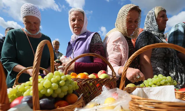 An apple fair takes place at the Saviour Monastery of St Euthymius during the Feast of the Transfiguration in Suzdal, Russia on August 19, 2020. Annually celebrated by the Russian Orthodox Church on August 19, it belongs to the Twelve Great Christian Feasts. In the Russian tradition, believers bring harvested apples to the church for blessing, hence the feast's another name Yablochny Spas (Apple Feast of the Saviour). (Photo by Vladimir Smirnov/TASS)