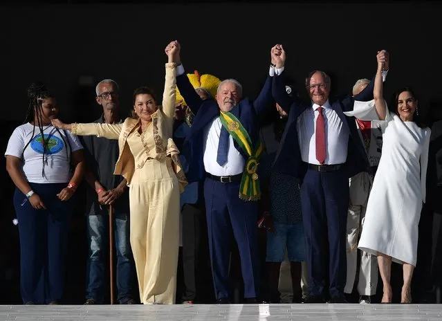 Brazil's new President Luiz Inacio Lula da Silva (C) and new Vice-President Geraldo Alckmin, with their wives First Lady Rosangela da Silva (2-L) and Maria Lucia Ribeiro Alckmin (R) respectively gesture at supporters at Planalto Palace after their inauguration ceremony at the National Congress, in Brasilia, on January 1, 2023. Lula da Silva, a 77-year-old leftist who already served as president of Brazil from 2003 to 2010, takes office for the third time with a grand inauguration in Brasilia. (Photo by Carl de Souza/AFP Photo)