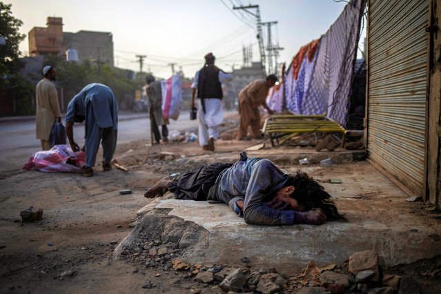 A homeless man, who workers in the vicinity said was suffering from a drug addiction, lies unconscious in Raja Bazar, Rawalpindi, Pakistan on May 21, 2025. (Photo by Adrees Latif/Reuters)