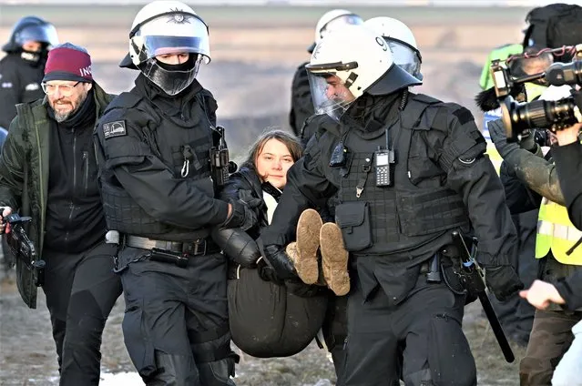 Police officers carry Swedish climate activist Greta Thunberg away from the edge of the Garzweiler II opencast lignite mine during a protest action by climate activists after the clearance of Luetzerath, Germany, Tuesday, January 17, 2023. After the eviction of Luetzerath ended on Sunday, coal opponents continued their protests on Tuesday at several locations in North Rhine-Westphalia. (Photo by Federico Gambarini/dpa via AP Photo)