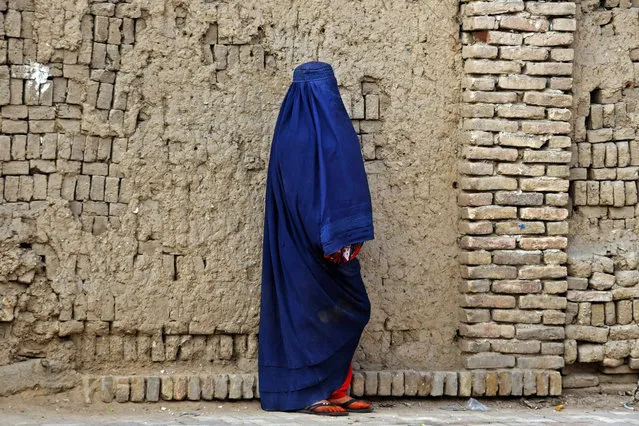 An Afghan burqa-clad woman walks through a street in Kandahar on December 25, 2022. (Photo by Naveed Tanveer/AFP Photo)
