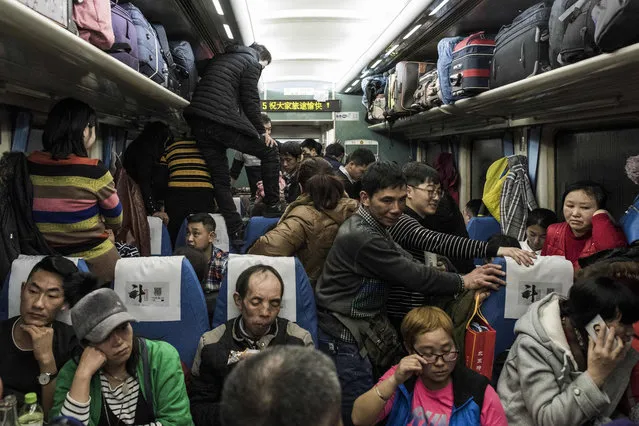 This photo taken on February 10, 2018 shows passengers travelling on a crowded train during the 26- hour journey from Beijing to Chengdu, in Shijiazhuang, as they head home ahead of the Lunar New Year. China is in the midst of its annual travel rush as millions head to their hometowns to enjoy a week- long holiday. The Lunar New Year begins on February 16, and authorities expect more than 390 million train trips to take place between February 1 and March 12. (Photo by Fred Dufour/AFP Photo)