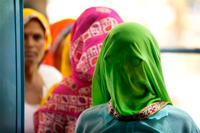 Women wait to cast their votes during the first round of voting of India's national election in Behror, Rajasthan state, India, Friday, April 19, 2024. Nearly 970 million voters will elect 543 members for the lower house of Parliament for five years, during staggered elections that will run until June 1. (Photo by Manish Swarup/AP Photo)
