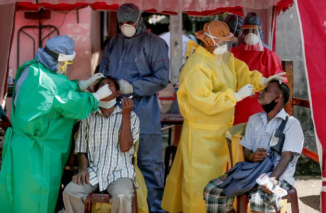 Health officials use swabs to collect test samples from people at a main market, amid concerns about the spread of the coronavirus disease (COVID-19), in Colombo, Sri Lanka, August 28, 2020. (Photo by Dinuka Liyanawatte/Reuters)