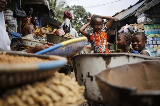 Children play around a local market where general goods and food items are sold in Abidjan,  Ivory Coast, Wednesday, October 21, 2015. (Photo by Schalk van Zuydam/AP Photo)