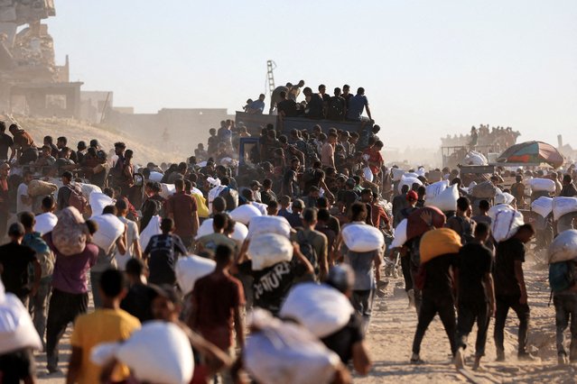 Palestinians carry aid supplies that entered Gaza through Israel, in Beit Lahia in the northern Gaza Strip on July 30, 2025. (Photo by Dawoud Abu Alkas/Reuters)