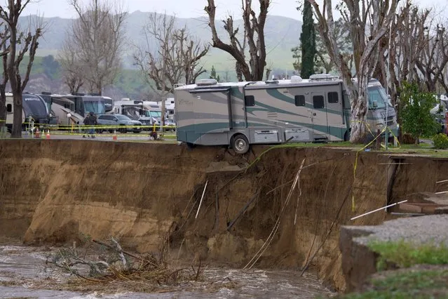 An RV begins to fall into the Santa Clara River as the ground bellow it is washed away by flooding due to heavy rain washing away over 150 feet of land and multiple RV homes in Castaic, California, on February 25, 2023. A major storm with a blizzard warning for parts of Southern California is expected to deliver damaging rain and snow at elevations lower than normal in Los Angeles County. (Photo by Allison Dinner/AFP Photo)