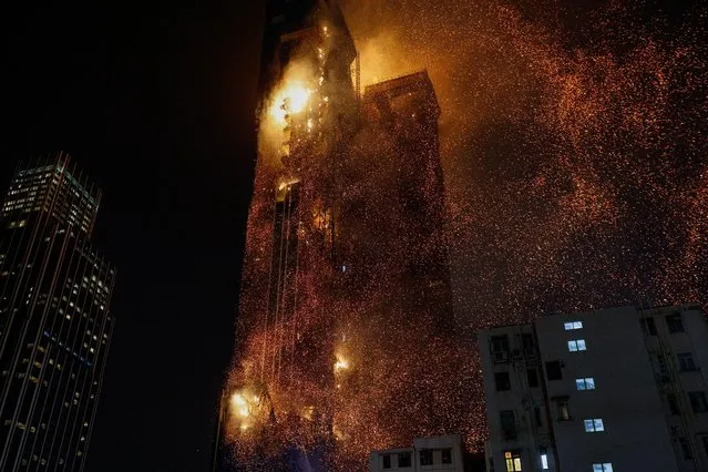 A building is seen on fire in Hong Kong, China on March 3, 2023. A fire tore through the upper floors of an under-construction skyscraper in the Tsim Sha Tsui area of Hong Kong in the early hours of Friday. (Photo by Tyrone Siu/Reuters)