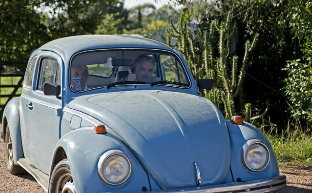 In this May 2, 2014 file photo, Uruguay's President Jose Mujica flashes a thumbs up as he and and his wife, Sen. Lucia Topolansky, ride away from their home after giving an interview, on the outskirts of Montevideo, Uruguay. (Photo by Matilde Campodonico/AP Photo)