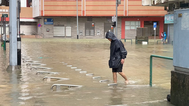 A man walks in a waterlogged street in the aftermath of Super Typhoon Ragasa in Macau, China, on September 24, 2025. (Photo by Reuters/Stringer)