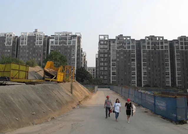 People walk in a construction site near a residential complex in Changsha, Hunan province, China, September 24, 2016. (Photo by Yawen Chen/Reuters)