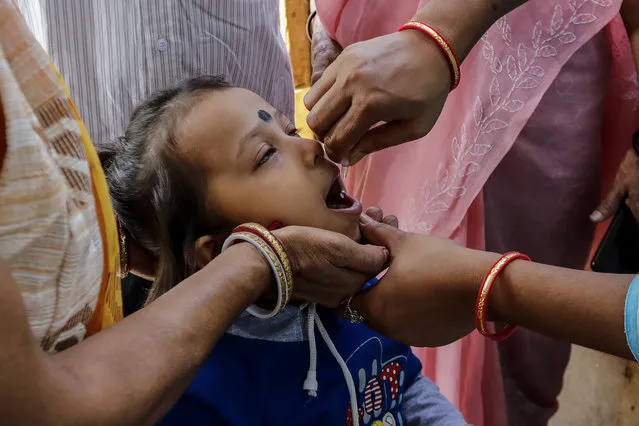 A child is administered polio vaccine at a booth in Kolkata, India, Sunday, November 22, 2020. India's total number of coronavirus cases since the pandemic began has crossed 9 million. (Photo by Bikas Das/AP Photo)