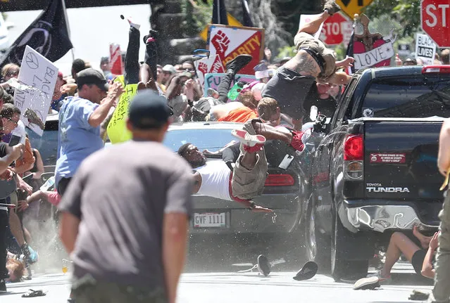 Car attack: People are thrown into the air as a car plows into a group of protesters demonstrating against a Unite the Right rally in Charlottesville, Va., August 12, 2017. The white nationalist rally, opposing city plans to remove a statue of Confederate icon General Robert E. Lee, attracted counter-protests. James Alex Fields Jr drove his car at high speed into a sedan, propelling it and a minivan into a group of anti-racist protesters, killing Heather Heyer (32) and injuring a further 19 people. Fields fled the scene in his own vehicle, but was stopped by Charlottesville police and later charged with murder. (Photo by Ryan M. Kelly/The Daily Progress/World Press Photo)