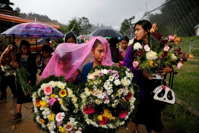 Girls carry wreaths during the funeral procession of Claudia Gomez, a 19-year old Guatemalan immigrant who was shot by a U.S. Border Patrol officer, in San Juan Ostuncalco, Guatemala June 2, 2018. (Photo by Luis Echeverria/Reuters)