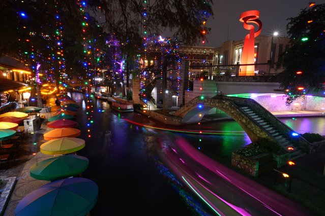 In a timed exposure, lighted barges move along the Riverwalk decorated with holiday lights, Wednesday, December 3, 2025, in San Antonio. (Photo by Eric Gay/AP Photo)