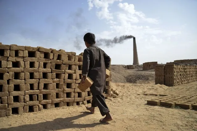 An Afghan boy works at a brick kiln in Dand district, Kandahar Province, on May 23, 2023. (Photo by Sanaullah Seiam/AFP Photo)