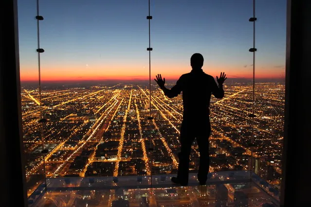 “If Only I Could Fly”. Spontaneous moment captured contemplating a beautiful and colorful sunset with all city lights down below. Location: Skydeck, Willis Tower, Chicago, Illinois. (Photo and caption by Gustavo Santos/National Geographic Traveler Photo Contest)