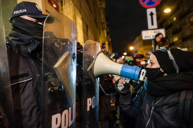 A protesters chants slogans on a megaphone towards the riot police officers during the protest in Warsaw, Poland on November 23, 2020: “Free Abortion and Free Education!”. The Women's Strike rallied again in Warsaw to protest the Constitutional Court's ruling on abortion. The blockade covered, among others MEN (Ministry of National Education). Some of the demonstrators chained themselves to the gate of the ministry. Police officers detained several people, including a journalist who was supposed to violate the inviolability of a policeman during the protest. From the Ministry, the demonstrators moved to the police station to show solidarity with the detained persons. (Photo by Attila Husejnow/SOPA Images/Rex Features/Shutterstock)