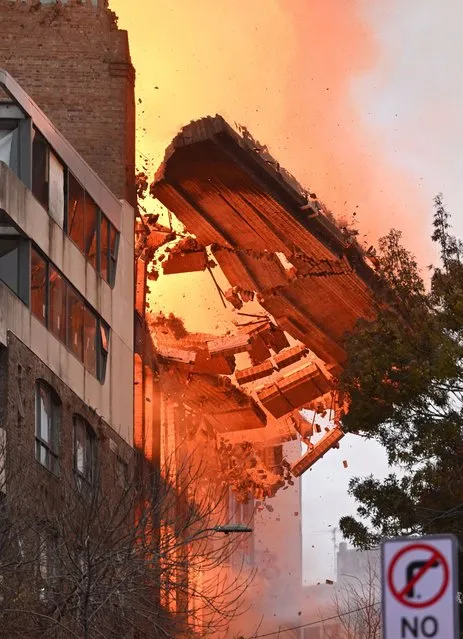 A wall collapses during a building fire in the Central Business District of Sydney, Australia, 25 May 2023. Fire and Rescue New South Wales said more than 100 firefighters were deployed to the area to battle the fire that erupted in the seven-storey building. (Photo by Dean Lewins/EPA)