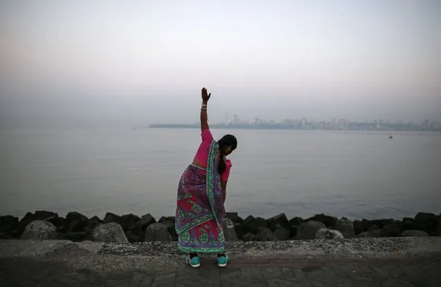 A woman wearing a saree, a traditional cloth used for women's clothing, exercises along the Arabian Sea in Mumbai January 22, 2015. (Photo by Danish Siddiqui/Reuters)