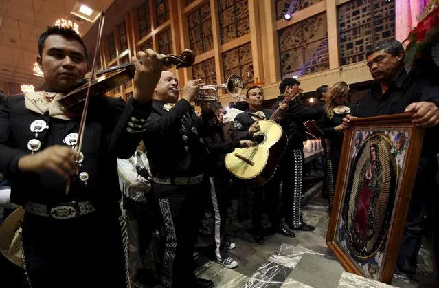 A group of Mariachis plays as a pilgrim holds an image of the Virgin of Guadalupe during an annual pilgrimage in honor of the Virgin, the patron saint of Mexican Catholics, at the Cathedral of Ciudad Juarez, Mexico December 12, 2015. (Photo by Jose Luis Gonzalez/Reuters)