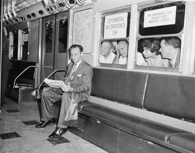 While other subway passengers perspire in the warm and humid underground station, Paul Forman appears cool and comfortable in the experimental air conditioned train which made its first run in New York City, July 9, 1956. The test run, which included six air conditioned cars and two old cars, was made on the East Side IRT line. (Photo by Harry Harris/AP Photo)