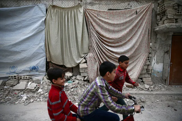 Children play near a damaged building in the rebel-held besieged city of Douma, in the eastern Damascus suburb of Ghouta, Syria November 13, 2016. (Photo by Bassam Khabieh/Reuters)