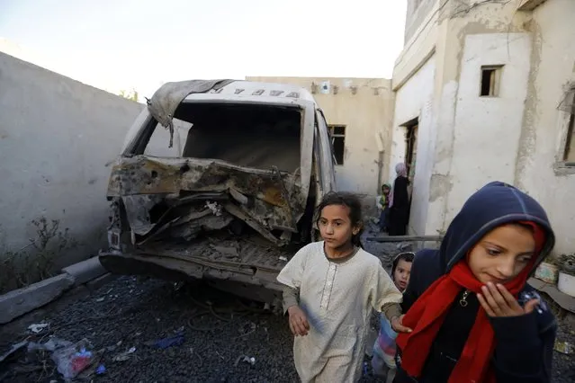 Children walk past a damaged vehicle at the site of an explosion in Sanaa January 23, 2015. Two improvised explosive devices went off outside houses of Houthi families in Sanaa on Friday, but no casualties were reported, police said. (Photo by Khaled Abdullah/Reuters)