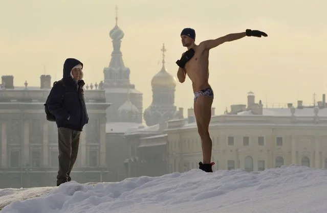 A man warms up prior to swimming in an ice hole in the Neva River St. Petersburg, Russia, Wednesday, February 10, 2021. The temperature in St. Petersburg is –15C ( 5 °F). (Photo by Dmitri Lovetsky/AP Photo)