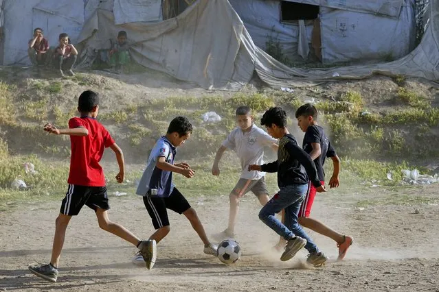 Syrian children play soccer by their tents at a refugee camp in the town of Bar Elias, in Lebanon's Bekaa Valley, Tuesday, June 13, 2023. Aid agencies are yet again struggling to draw the world's attention back to Syria in a two-day donor conference hosted by the European Union in Brussels for humanitarian aid to Syrians that begins Wednesday. Funding from the conference also goes toward providing aid to some 5.7 million Syrian refugees living in neighboring countries, particularly Turkey, Lebanon and Jordan. (Photo by Bilal Hussein/AP Photo)