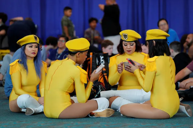 Attendees check their phones as they take a break during opening day of pop culture convention Comic Con International in San Diego, USA on Thursday, July 19, 2018. (Photo by Mike Blake/Reuters)