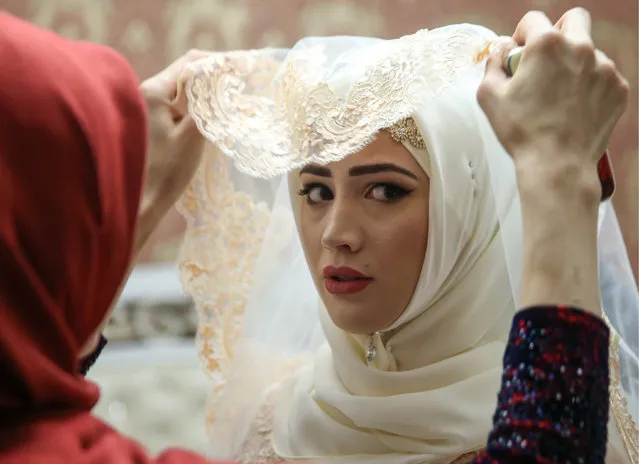 Relatives help the bride prepare for her wedding in Chechen capital Grozny, Russia on November 24, 2016. (Photo by Valery Sharifulin/TASS)