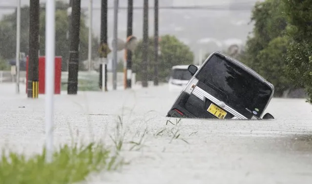 A vehicle is stuck on a street flooded due to a heavy rain in Kurume, Fukuoka prefecture, southern Japan Monday, July 10, 2023. Torrential rain is pounding southwestern Japan, triggering floods and mudslides Monday as weather officials issued emergency heavy rain warning in parts of on the southern most main island of Kyushu. (Photo by Kyodo News via AP Photo)