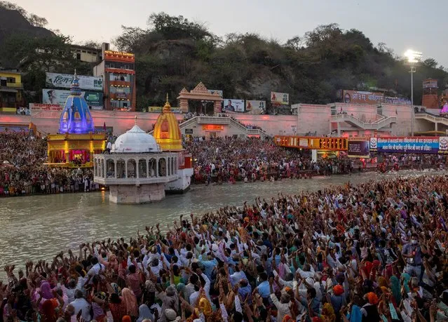 Devotees gather for an evening prayer on the banks of Ganges river during Kumbh Mela, or the Pitcher Festival, amidst the spread of the coronavirus disease (COVID-19), in Haridwar, India, April 11, 2021. (Photo by Danish Siddiqui/Reuters)