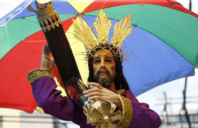A Black Nazarene replica is paraded under an umbrella two days before the annual procession of the Black Nazarene in Manila January 7, 2016. (Photo by Erik De Castro/Reuters)