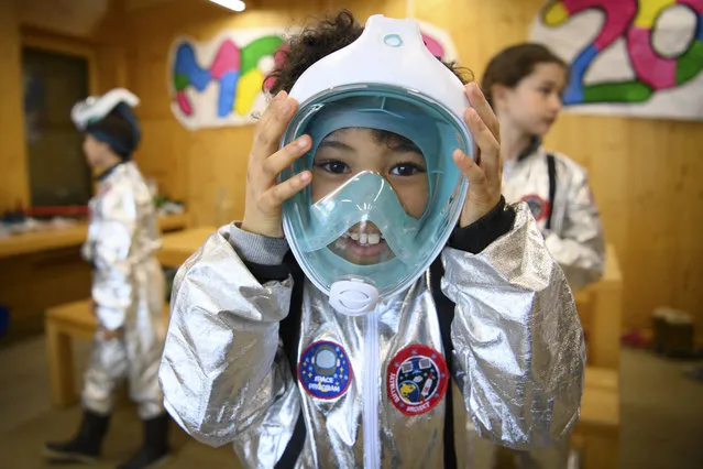 8 year old students of the private school Vivalys dressed as astronauts prepare themselves by putting on their mask to go out and perform the experiment of the germination of a seed as they conduct a three days simulation of life in a space base on the planet Mars during the coronavirus disease (COVID-19) outbreak, in Lausanne, Switzerland, 18 March 2021. The students underwent specific training to acquire new knowledge in mathematics, physics, botany and social sciences. (Photo by Laurent Gilliéron/EPA/EFE)