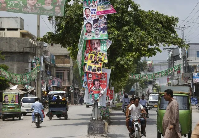 Banners of election candidates from political parties are displayed on a road in Rawalpindi, Pakistan, Tuesday, July 24, 2018. As Pakistan prepares to make history Wednesday by electing a third straight civilian government, rights activists, analysts and candidates say the campaign has been among its dirtiest ever, imperiling the country's wobbly transition to democratic rule. (Photo by Anjum Naveed/AP Photo)