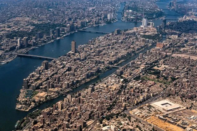 This aerial view taken on April 28, 2023 shows the historic Mosque of Amr ibn al-Aas (bottom R) in the Fustat and Coptic Cairo district and the Nile island district of Manial al-Roda (C), with Cairo's twin-city of Giza across the river (L). (Photo by Amir Makar/AFP Photo)