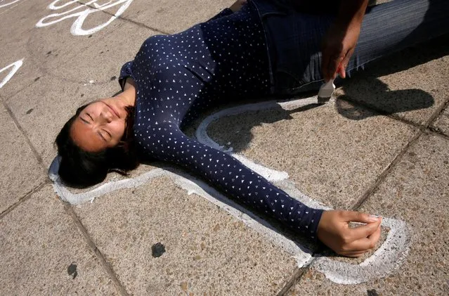 A demonstrator lies on a silhouette that represents a victim of violence being painted by an activist of the organization Nos hacen falta (We are missing them), during a demonstration demanding justice for the victims of violence and drugs, at the Monument to the Revolution in Mexico City, Mexico December 11, 2016. (Photo by Henry Romero/Reuters)