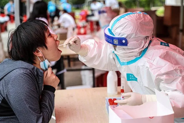 A health worker takes a swab sample from a resident to test for the Covid-19 coronavirus in Shenyang, in northeastern China's Liaoning province on May 20, 2021. (Photo by AFP Photo/China Stringer Network)