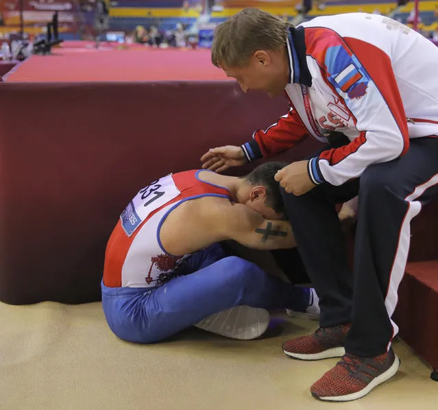 A coach comforts Russia's Artur Dalaloyan after the team lost the men's team final of the Gymnastics World Chamionships with a small margin at the Aspire Dome in Doha, Qatar, Monday, October 29, 2018. China's team total of 256.634 was less than five-hundredths of a point clear of Russia's total of 256.585 during a tense but occasionally sloppy final. (Photo by Vadim Ghirda/AP Photo)
