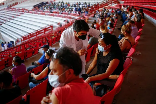 A woman receives the Pfizer-BioNTech coronavirus disease (COVID-19) vaccine, during a mass vaccination program for people over 50 years of age at a baseball stadium in Ciudad Juarez, Mexico on June 22, 2021. (Photo by Jose Luis Gonzalez/Reuters)