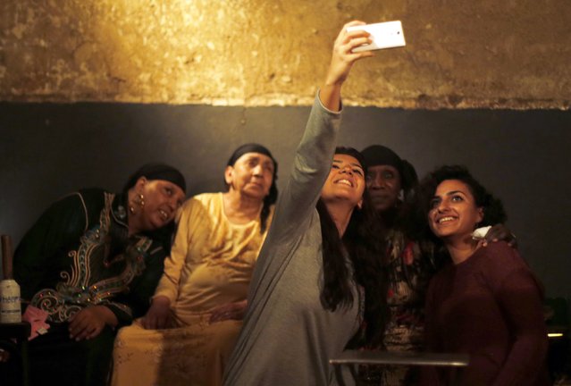 Women take a “selfie” with musicians and healers of band “Mazaher Zar” after the band performed a traditional exorcism ritual in Cairo in this November 12, 2014 file photo. (Photo by Amr Abdallah Dalsh/Reuters)