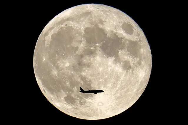 This photograph taken on September 29, 2023 shows an Airbus A319-111 of Easyjet airlines approaching Toulouse-Blagnac airport and flying under the full moon. (Photo by Charly Triballeau/AFP Photo)